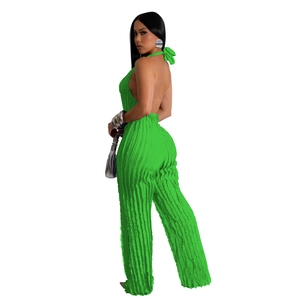 Detailed view of neon green pleated fabric on a backless halter wide-leg jumpsuit