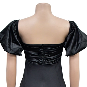 Detail of black puff sleeve dress with open back design and ruching texture