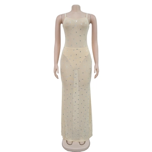 Détail du tissu en maille avec strass denses et perles de cristal sur une robe longue nude