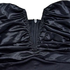 Detailed macro shot of the front zipper and ruched fabric on this black satin dress