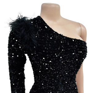 Detail of black sequined dress featuring elegant feather shoulder trim and shimmering texture