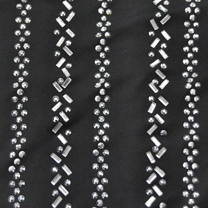 Detail of vertical rhinestone stripes on black fabric for an elegant evening dress design