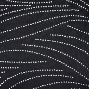 Detailed macro view of black mesh fabric featuring a wavy pattern of silver rhinestones