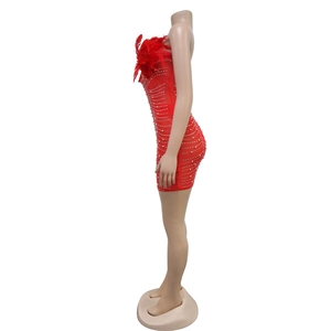 Close-up of red sequined bodycon dress featuring feather trim and sparkling rhinestones
