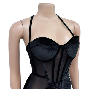 Dettaglio di pannelli in velluto e mesh su un corsetto nero con spalline