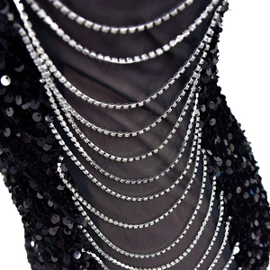 Detail of black sequin dress with elegant mesh fabric and draped rhinestone chains