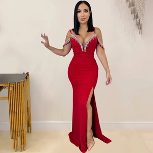 Détail de robe de soirée rouge avec franges perlées argentées et fente haute sur la jambe