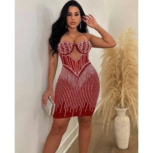Détail d'une mini-robe moulante rouge avec découpe en U et strass scintillants