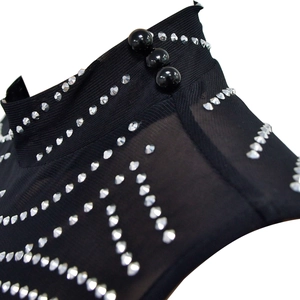 Detail of sheer black mesh mock neck with shimmering rhinestones and pearl buttons