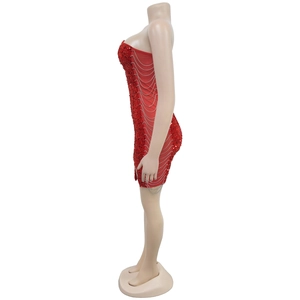 Detail of red sequin mini dress with sheer mesh side panels and silver metal chains
