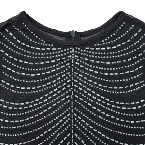 Detail of round neckline with mesh fabric and geometric rhinestone pattern on black dress