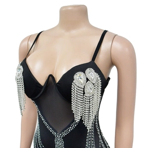 Dettaglio del body in rete nera con strass a forma di pera e frange decorative
