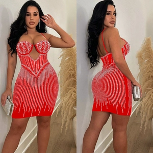 Détail de la robe moulante rouge avec strass argentés et découpes en résille fines