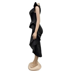Detail of elegant black slim-fit dress featuring side cascading ruffles and sleek fabric