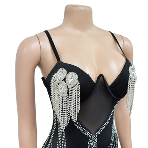 Dettaglio di body nero in rete con strass a goccia e lunghe nappe di cristallo scintillante