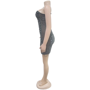 Detailed view of the layered metal chain accessories on a sequined charcoal mini dress