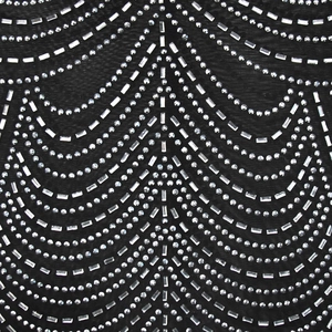 Close-up of black mesh fabric with intricate silver rhinestone wave patterns and details
