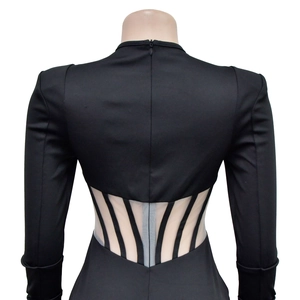 Detail view of the intricate skeletal cut-out back design on a black mesh sleeve dress