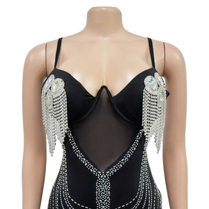 Dettaglio di un body nero con strass, inserti in mesh e lunghe frange di cristalli lucidi