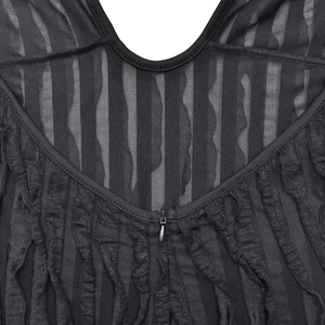 Detail of sheer black mesh fabric with layered ruffles and a hidden front zipper closure