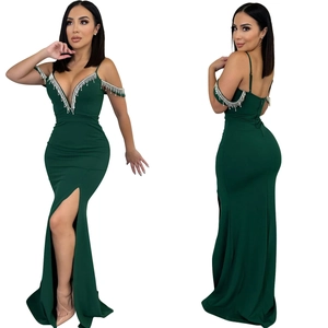 Détail de robe de soirée vert foncé avec franges argentées et fente latérale haute longue