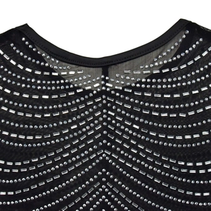 Detailed view of the neckline on a black mesh top featuring intricate silver rhinestone patterns