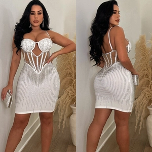 Détail d'une robe mini blanche de luxe ornée de perles et de franges en strass brillants