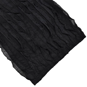 Detail of layered black ruffle pleats with sheer chiffon texture on a jumpsuit