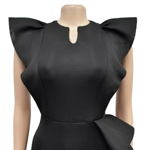 Detailed view of black sleeveless dress featuring ruffled shoulders and teardrop cutout neck