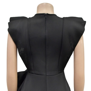 Detail view of black sleeveless dress back showing shoulder ruffles and hidden zipper