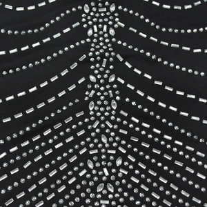 Dettaglio macro di tessuto a rete nero con strass scintillanti in motivi a onde