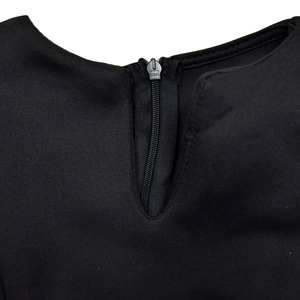 Detailed macro view of the neckline zipper and black fabric texture on this dress
