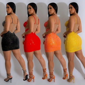 Détail de mini-robes en maille noire, rouge, orange et jaune avec des paillettes brillantes