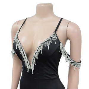 Détail du décolleté en V profond avec franges de strass argentés sur une robe de soirée noire