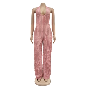 Detail of pink halter neck jumpsuit featuring deep U-neckline and ruffled pleated fabric