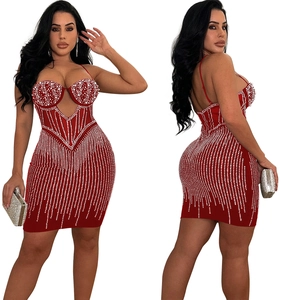 Détail d'une mini-robe rouge en mesh avec strass étincelants et ornements en perles