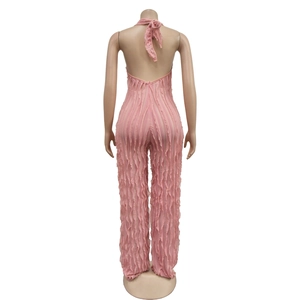 Detail view of pink backless jumpsuit with vertical pleated texture and halter neck tie