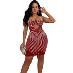 Détail de la robe courte rouge moulante avec strass argentés et design corset en résille