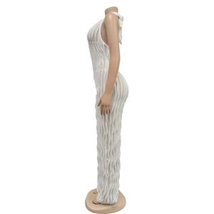 Detailed side view of white backless jumpsuit featuring pleated ruffles and sheer fabric