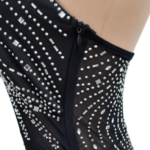 Détail de strass argentés et paillettes sur maille noire avec fermeture éclair latérale