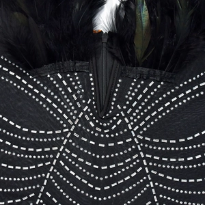 Detail eines schwarzen Jumpsuits mit Mesh-Strass-Webmuster und weichem Federbesatz