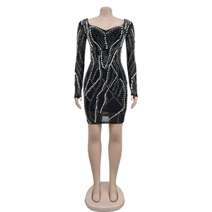 Detailed view of wave-patterned rhinestones and pearls on black mesh mini dress