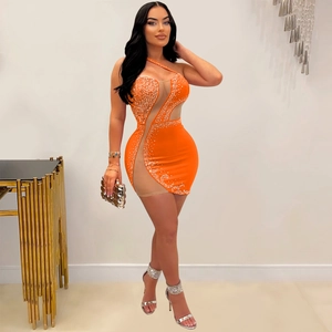 Macro view of orange rhinestone mini dress featuring sheer mesh inserts and sparkling details