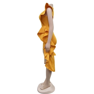 Detail of vibrant ginger yellow one-shoulder dress with layered ruffles and asymmetric hem