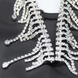 Détail des franges à strass argentés étincelants sur une robe en tissu noir