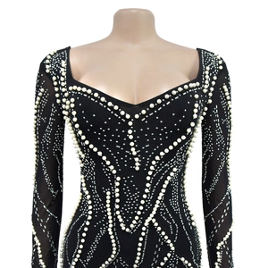 Detail of mesh dress with heart-shaped neckline, white pearls, and silver rhinestones