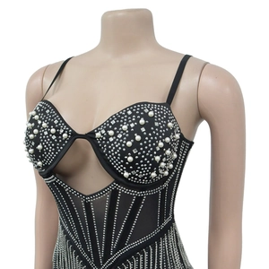 Détail de robe moulante en mesh avec strass et perles sur un tissu noir chic
