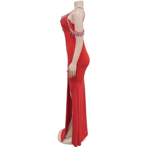 Détail d'une robe de soirée rouge avec des franges en strass et fente latérale
