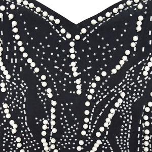 Detail of elegant black mesh dress featuring symmetric pearls and sparkling rhinestones