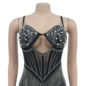 Détail d'un body en maille noire avec rayures en strass et bonnets ornés de perles
